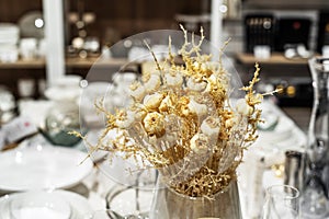 Artificial heads of garlic in a glass vase. Decorating kitchens with dry plants and flowers. Foreground. Selective focus