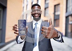 Happy black businessman in suit holding smartphone, using chatbot