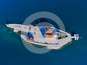 An artificial island in Montenegro with a tourist yacht moored. Top view