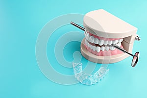 Artificial jaw, dental mirror and occlusal splint on color background