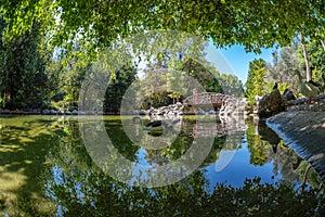 The artificial lake with the wooden bridge at the National Garden of Athens - Greece. It is a public park in the center of Athens