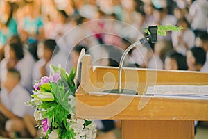 Artificial leaf inserted in the desktop microphone stand on podium in the auditorium