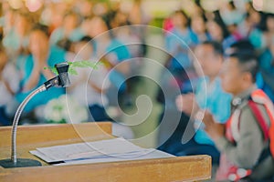 Artificial leaf inserted in the desktop microphone stand on podium in the auditorium