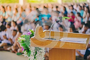 Artificial leaf inserted in the desktop microphone stand on  podium in the auditorium