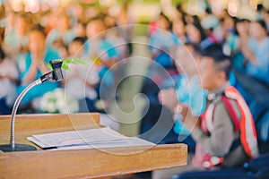 Artificial leaf inserted in the desktop microphone stand on podium in the auditorium