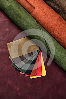 Artificial leather samples on a cow leather background. Top view.