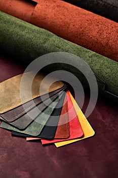 Artificial leather samples on a cow leather background. Top view.