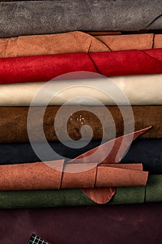 Artificial leather samples on a cow leather background. Top view.