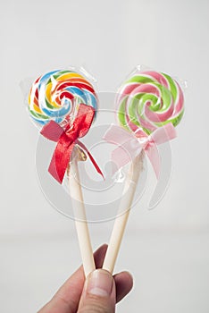 Artificial lollipops held by hand, isolated on white background