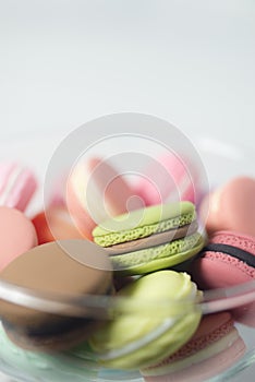 Artificial mini French macarons with various colors on glass isolated on white