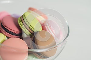 Artificial mini French macarons with various colors on glass isolated on white