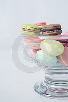 Artificial mini French macarons with various colors on glass isolated on white