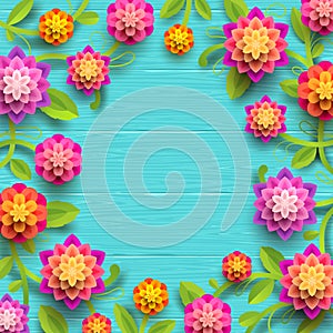 Artificial paper flowers on a blue wooden plank background with copy space in the center.