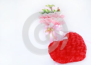 Artificial pink roses bouquet with red heart pillow isolated on white background