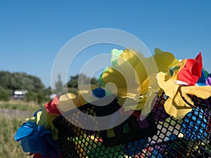 Artificial plastic flowers decorating a bike basket.