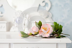 Artificial rose flowers on a white wooden table