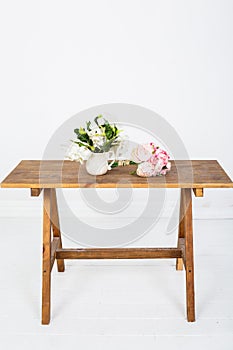 Artificial rose flowers on a white wooden table