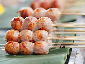 Artificial sausage Thai sausage casing cooking twine made from minced pork and rice take to grill put on green banana leaves