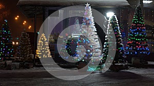 Artificial sparkling Christmas trees. Sale of Christmas trees at night. Christmas and New Year's Day. Christmas trees