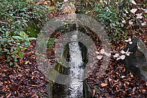 Artificial watercourse gutter in a stone bed in a park