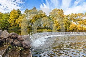 Artificial waterfall in the Drozdy Forest Park in Minsk, Belarus. Autumn landscape