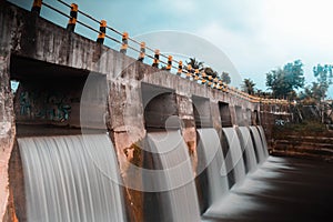 artificial waterfall in the river under bridge