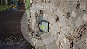 Artillery holes in wall with bomb hole at background. Side angle view of ruined damaged building bombed with missiles in