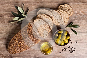 Artisan bread with olives and olive oil on a wooden table