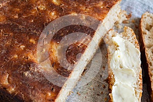 Artisan bread and slices of buttered bread, close-up. Concept of breakfast or healthy food