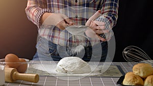 artisan bread working with dough. Use a sieve to sift flour into dough handmade bread with bakery equipment tools, black