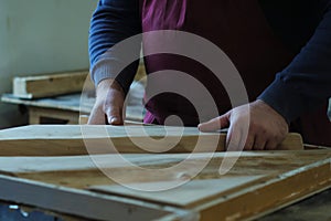 Artisan carefully positions a wooden slab in a resin mold. Precision here is key to crafting a seamless piece.