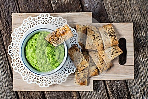 Artisan Crackers with green pea hummus spread.