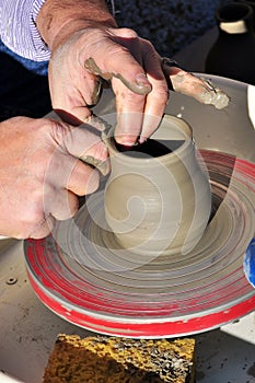 Artisan creates a clay pot with a lathe