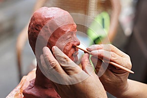 Artisan creating clay head photo