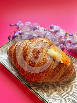 artisan croissant, fresh crispy croissant, cornetto with cream, purple wisteria,cup with coffee, small espresso, black background