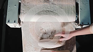 Artisan Dough Shaping, Hands shaping loaves on a floured surface in bakery.