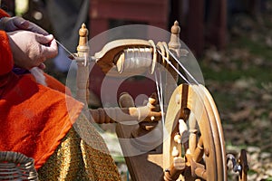 Artisan makes yarn with spinning wheel