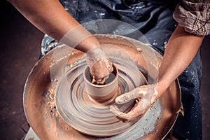 Artisan making pottery, sculptor from wet clay on wheel. Making ceramic dishes. Close-up.