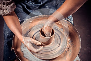 Artisan making pottery, sculptor from wet clay on wheel. Making ceramic dishes. Close-up.