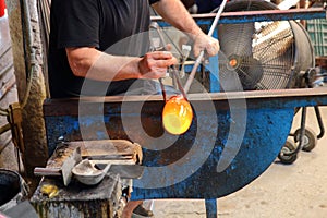 Artisan manufactures glass. Glassworks process. photo