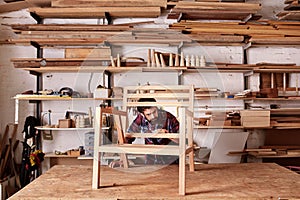 Artisan manufacturing a wooden chair frame in his studio