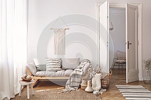 Artisan and natural decorations and accessories in a warm living room interior with wooden furniture and hardwood floor