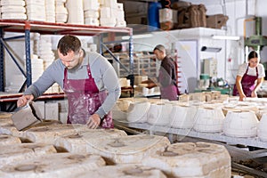 Artisan pouring slip into casting molds in pottery workshop