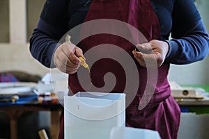 Artisan prepares resin mix, adding color to the clear medium. It& x27;s a step that brings vibrancy to the craft piece.