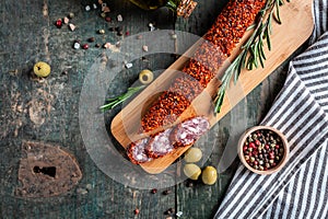 Artisan salami chorizo sausages made with paprika and garlic on cutting board on wooden table. Traditional Spanish sausage. banner