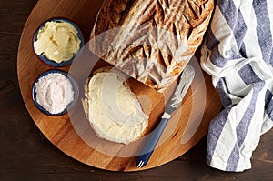 Artisan sourdough sliced toast bread with butter and pink himalayan salt on cutting board