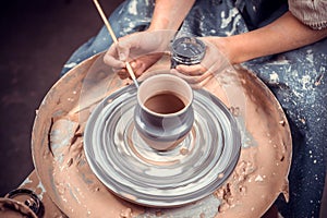 Artisan woman works with clay on a potter& x27;s wheel. Ceramics art concept. Close-up.