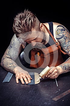 Artisan working with leather working with leatherwork at the leather shop