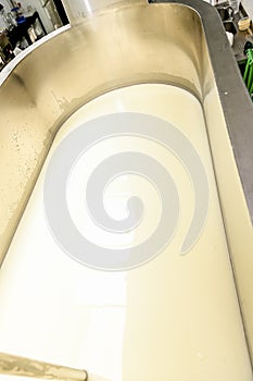 Artisanal cheese making, cutting the curd and whey in the factory tank