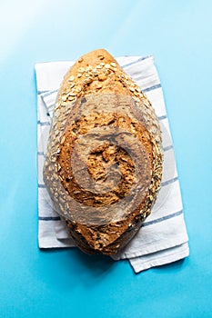 Artisanal sourdough bread with oat on a blue background. Top view